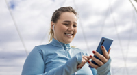 A woman in exercise clothes looking at her smartphone