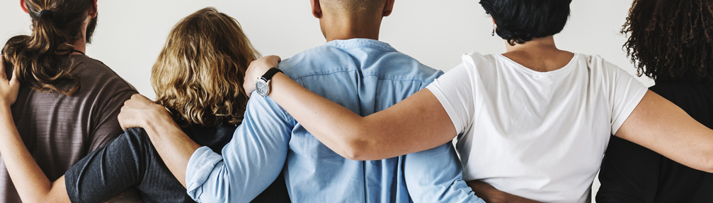 Diverse people, standing arm in arm.